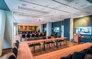 a conference room with tables and chairs and a bar at Scandic Continental in Stockholm