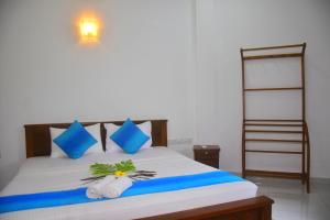 a bedroom with a bed with blue pillows and a ladder at Ceylon Relax Villa in Aluthgama