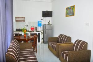 a living room with two chairs and a table and a kitchen at Ceylon Relax Villa in Aluthgama