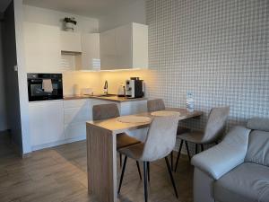 a kitchen with a table and chairs and a couch at Apartamenty AP 8 in Częstochowa