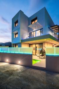 a blue house with a chair in front of it at Kokalas luxury villa in Georgioupolis