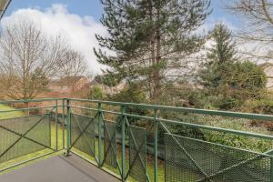 a balcony with a green railing and trees at Appart'City Classic Dijon - Toison D'Or in Ahuy