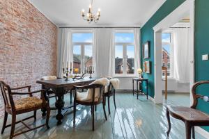 a dining room with a table and chairs and a brick wall at BELETAGE in Emden