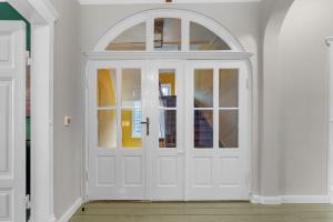 a white door with an arch in a room at BELETAGE in Emden