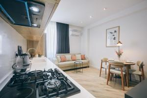a kitchen and living room with a stove top at Avant Park GK Aparts in Baku