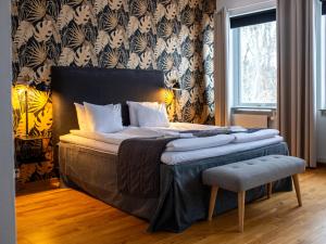a bedroom with a large bed with a chair at Hensbacka Hotell in Munkedal