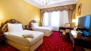 a hotel room with two beds and a desk at Meyra Palace in Ankara