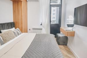 a bedroom with a bed and a flat screen tv at Avant Park GK Aparts in Baku