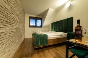 a bedroom with a bed and a bottle of wine at Penzión u Vinára in Veľký Krtíš +27 photos