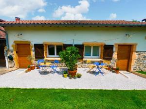 a patio with chairs and tables in front of a house at EVASION NATURE ET CONVIVIALITÉ in Sourcieux-les-Mines