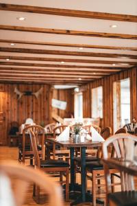 an empty restaurant with wooden tables and chairs at Hensbacka Hotell in Munkedal