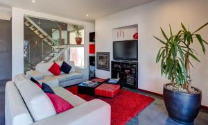 uma sala de estar com mobiliário branco e um vaso de plantas em Vila Cantinho Algarvio Vista Rio em Ferragudo