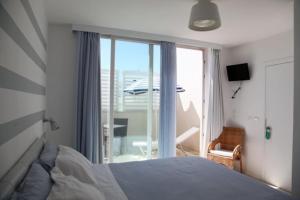 ein Schlafzimmer mit Bett und Blick auf einen Balkon in der Unterkunft Malù Bed&Breakfast in Polignano a Mare