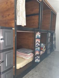 a black bunk bed in a room with clothes at Siril Guesthouse Hostel in Nuwara Eliya