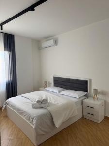 a bedroom with a large white bed and a window at Cloud 4 Apartment in Lezhë