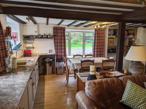 eine Küche und ein Wohnzimmer mit Sofa und Tisch in der Unterkunft Welsh Hideaways in Pentre-briwnant
