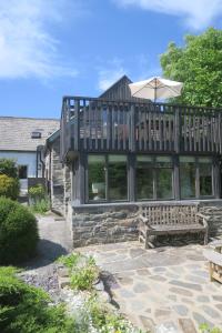 ein großes Haus mit Terrasse und Bank in der Unterkunft Welsh Hideaways in Pentre-briwnant