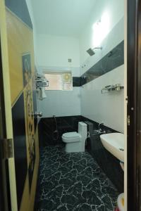 a bathroom with a toilet and a sink at ChanTini Inn in Velankanni