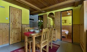 a dining room with a table and chairs and a bedroom at Chaty Jasná in Belá