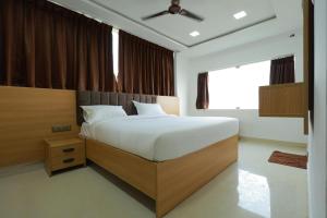 a bedroom with a large bed and a large window at ChanTini Inn in Velankanni