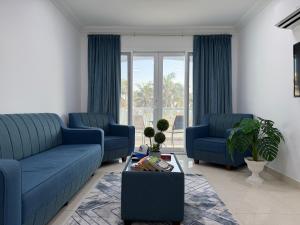 a living room with two blue couches and a table at Beautiful Salalah Beach Apartments - 1 by Beautiful Salalah Tours in Salalah