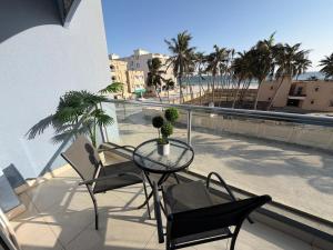 a patio with a table and chairs on a balcony at Beautiful Salalah Beach Apartments - 1 by Beautiful Salalah Tours in Salalah