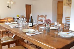 a wooden table with glasses and a bottle of wine at Mas des Druilles in Générargues