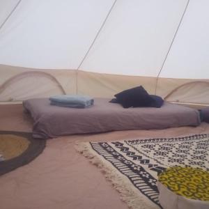 a bed in a tent with pillows on it at Tente Tipi en plein cœur d'une forêt in Burzet