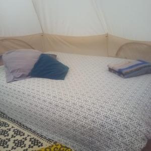 a bed in a tent with a pillow on it at Tente Tipi en plein cœur d'une forêt in Burzet