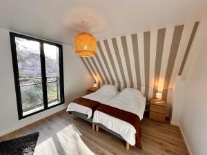 a bedroom with a bed and a striped wall at Gîtes du Point de Vue & du Causse d'Autoire in Autoire +56 photos