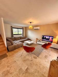 a living room with a couch and a tv at Gîtes du Point de Vue & du Causse d'Autoire in Autoire