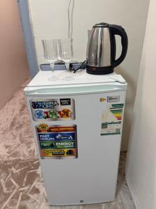 a refrigerator with a tea kettle on top of it at SAMA Economic Apartment in Medina +10 photos