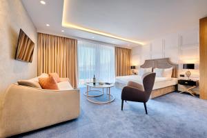 a hotel room with a bed and a chair at Kalamper Hotel & Spa in Dobra Voda
