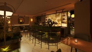 a bar in a restaurant with chairs and tables at KiN Hotel Central Park in Ho Chi Minh City