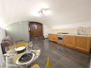 a kitchen with a glass table and a counter top at Dimora Di Davide in LʼAquila