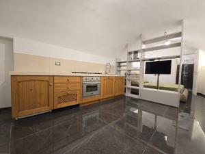 a kitchen with wooden cabinets and a flat screen tv at Dimora Di Davide in LʼAquila