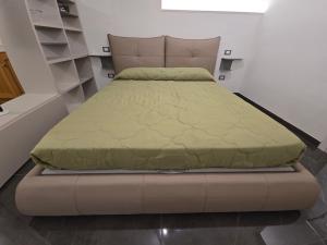a large bed in a room with a bed frame at Dimora Di Davide in LʼAquila