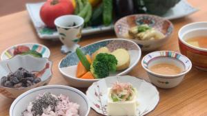 a table topped with bowls of food and bowls of soup at ウェルネスハウスさらい in Nomi