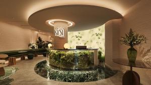 a lobby with a large aquarium in the middle of a room at KiN Hotel Central Park in Ho Chi Minh City