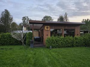 a small wooden house in a field of grass at Tīkli 3 in Bigauņciems