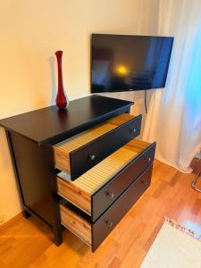a black dresser with a vase on top of it at Freudenstadt City Apartment in Freudenstadt