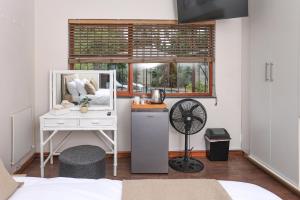 a bedroom with a desk with a mirror and a window at African Oasis Morrocco in Somerset West