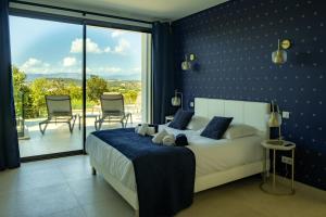 a bedroom with a large bed with a blue wall at VILLA IMPERIALE vue mer piscine in Pietrosella +35 photos