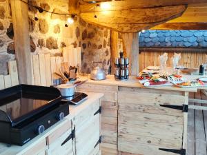 a kitchen with wooden cabinets and a counter with food at La Maison de Jeanne, maison d'hôtes in Thiézac