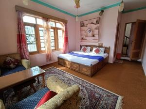 a bedroom with a bed and a couch and a table at Inayat hotel in Srinagar