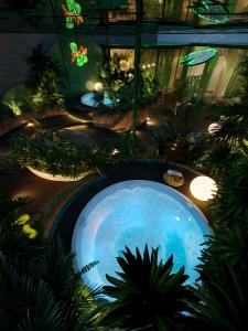 a large swimming pool in a room with plants at KiN Hotel Central Park in Ho Chi Minh City