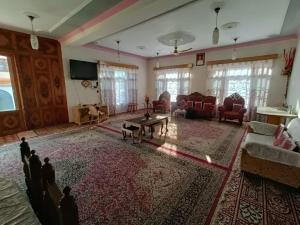 a living room with a couch and a table at Inayat hotel in Srinagar