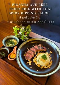 a plate of food with a steak on a table at Sireha Cafe Resort and Glamping in Ban Khok Chang