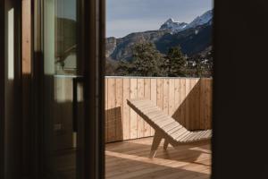 a chair on a balcony with a view of a mountain at Hotel Chalet Rezia in Chiesa in Valmalenco