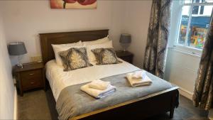 a bedroom with a bed with two towels on it at The Pack Horse in Louth